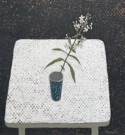 single stem of white phlox flowers in a blue patterned vase on a white table